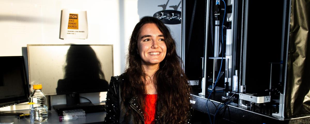 Minel Arinel sitting beside lab equipment