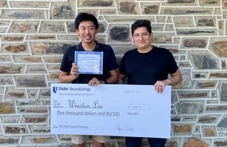 Winston Liu and Diego Bohorquez stand with giant check for $1000