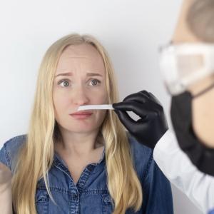 photo of worried woman sniffing a scent strip of paper