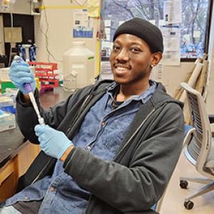Josiah Sampson IV with pipette in lab