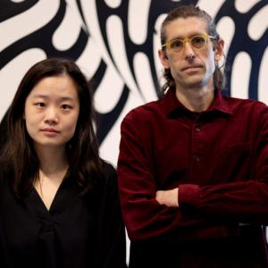 Tim Dunn and a collaborator standing in front of geometric background